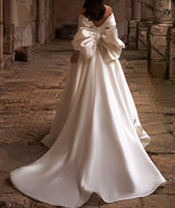 Ellegant off shoulder wedding dress. Satin bow back bridal gown.